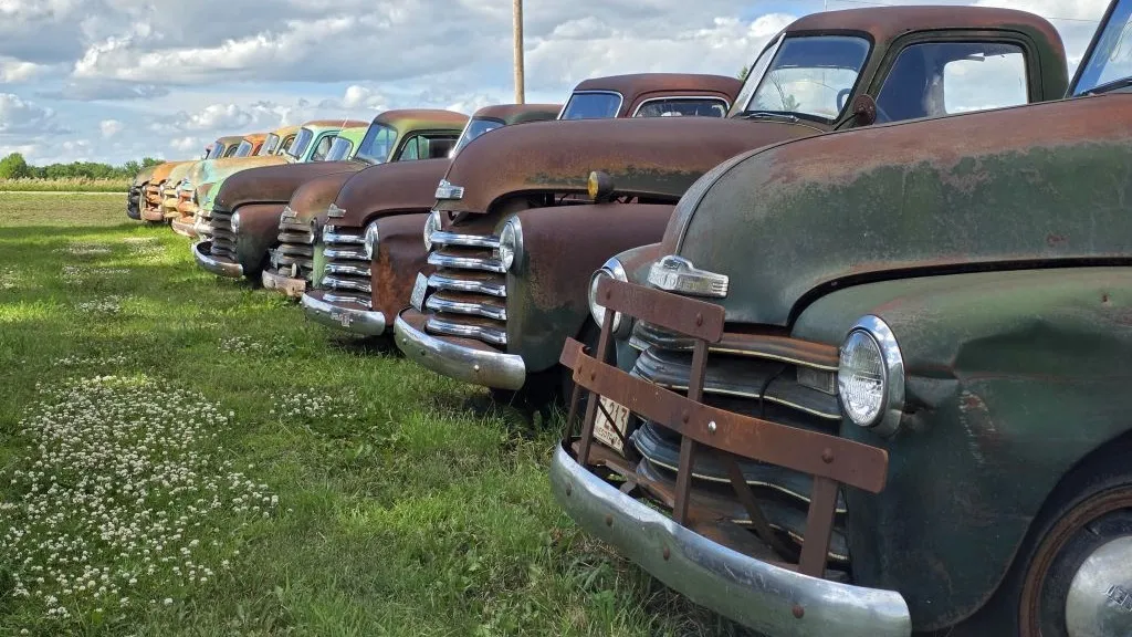 line of old trucks headed to auction