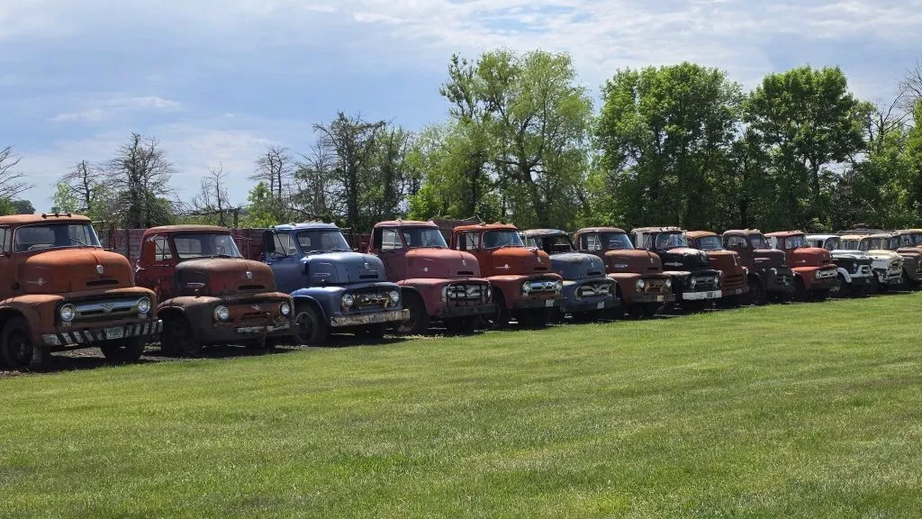 line of old trucks headed to auction
